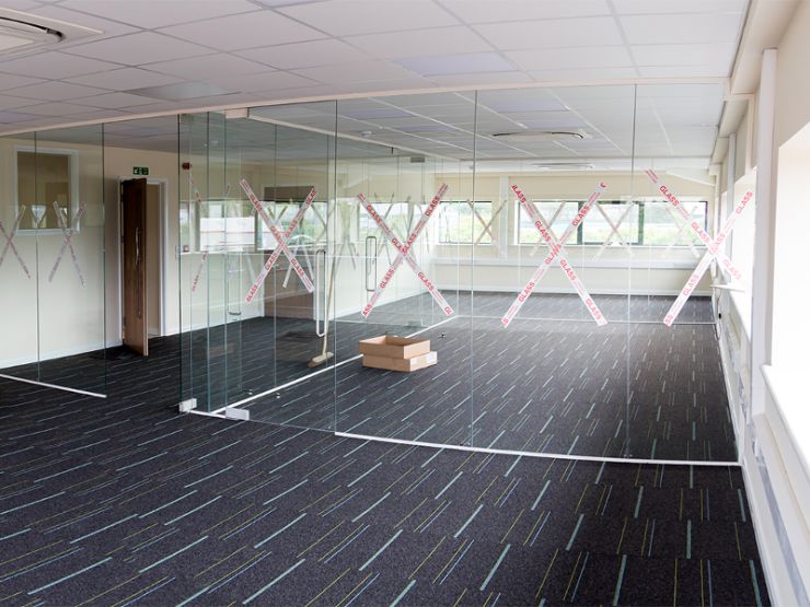 office area decorated with trunking installed to gice electrics and data, air conditioning installed, carpeted and glass partitions to finish it all off